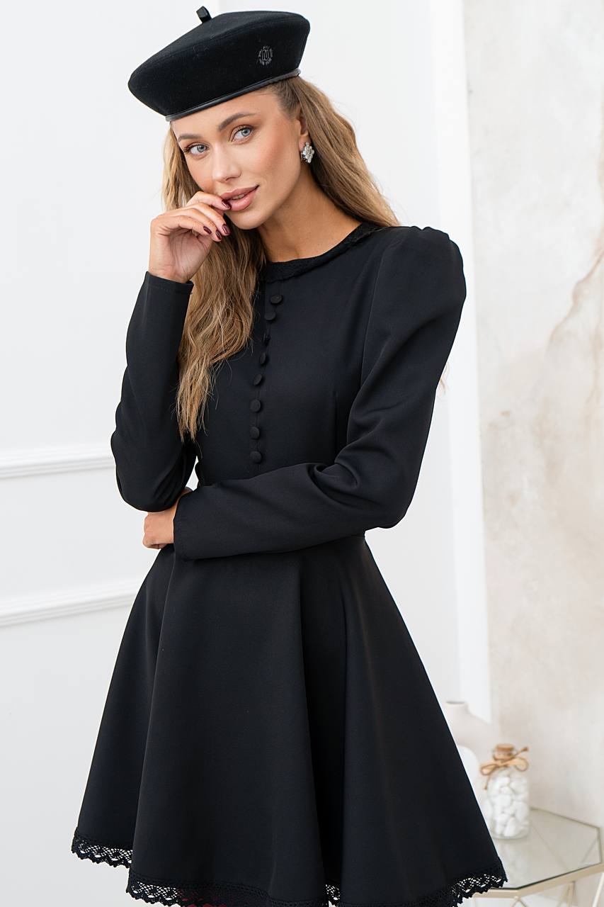 Woman wearing a black dress and beret against a white background