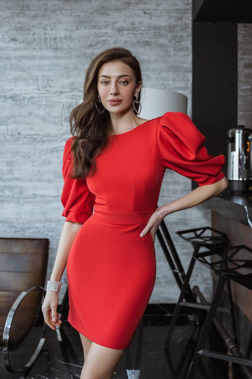 Woman in a red dress standing in a modern indoor setting