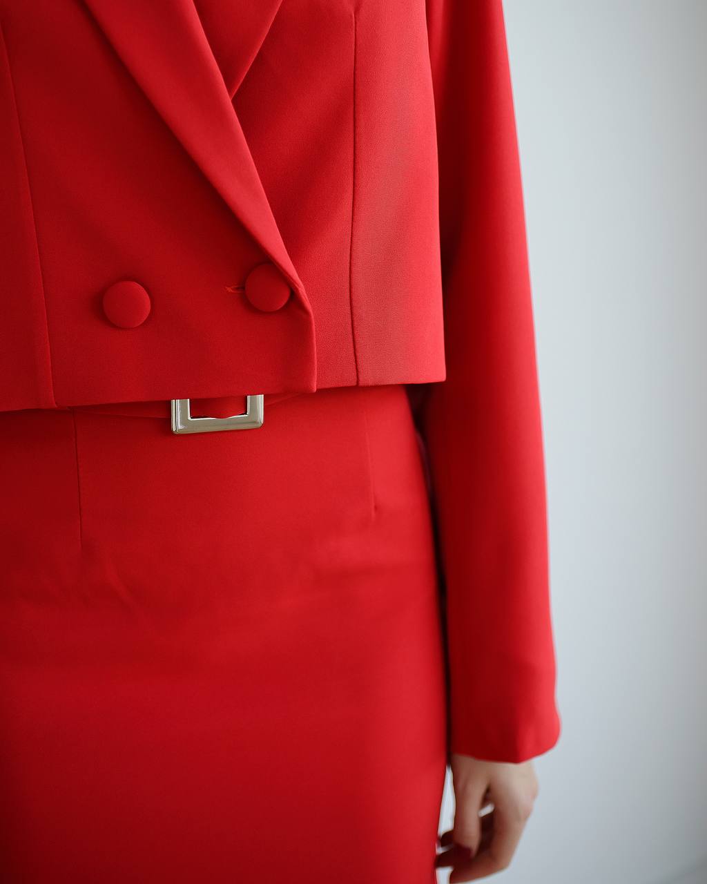 Red coat with a silver belt on a plain background