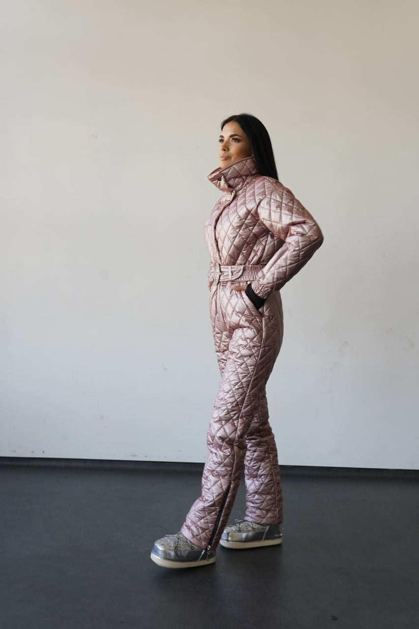 Person wearing a pink quilted snowsuit standing against a plain background