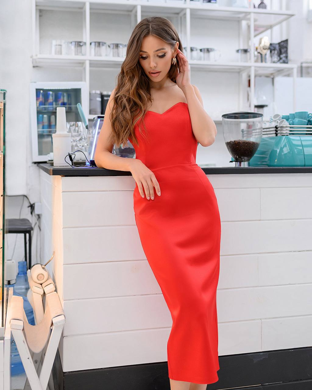 Woman in a red dress standing in a kitchen.
