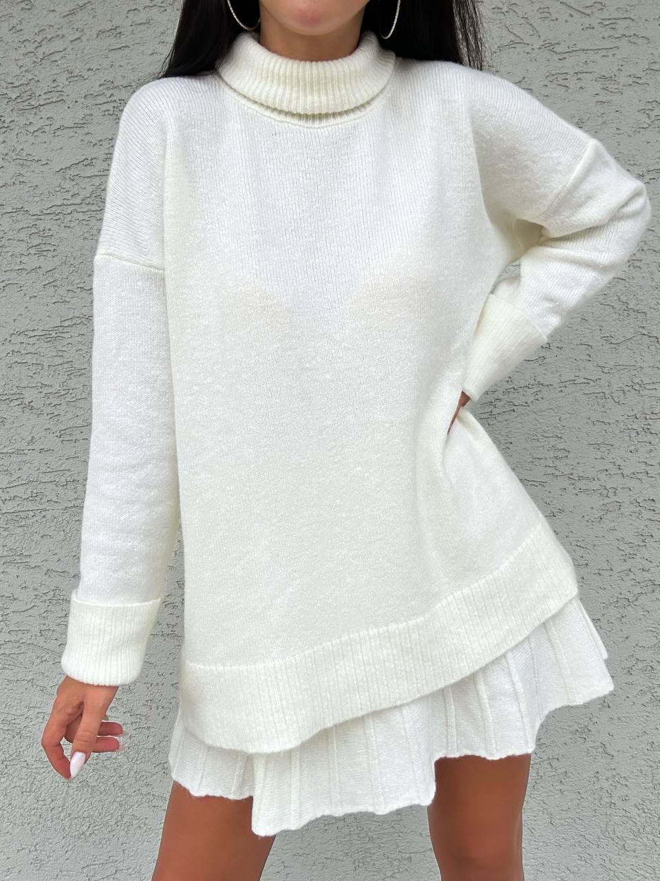 White sweater and skirt set against a gray background