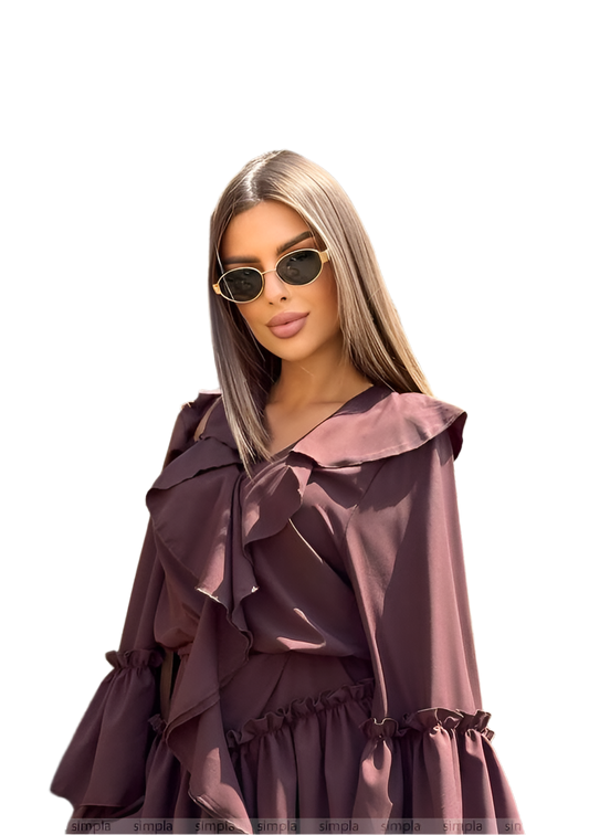 Woman wearing a ruffled, long-sleeve dress with sunglasses on a white background