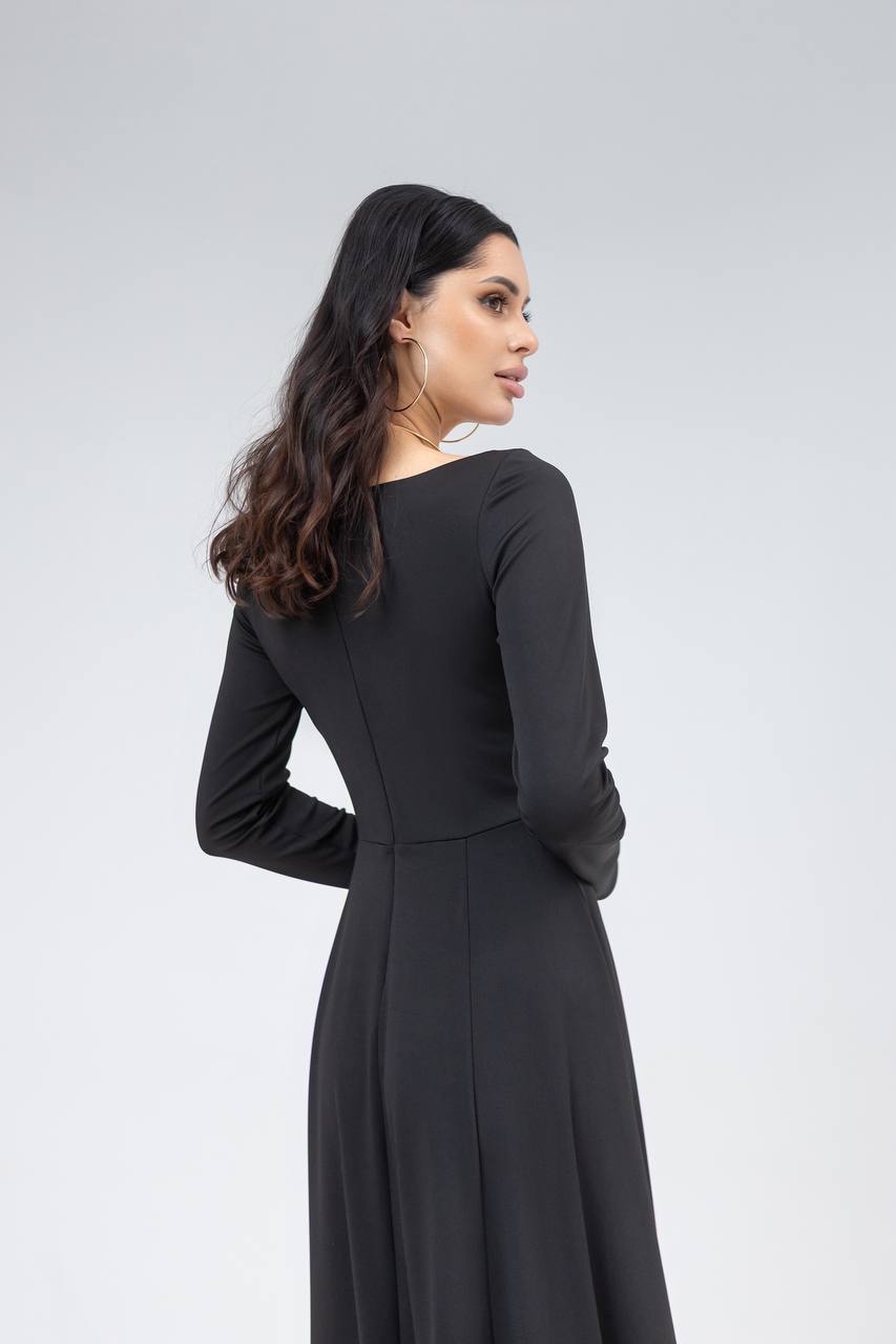 Woman wearing a black dress against a gray background