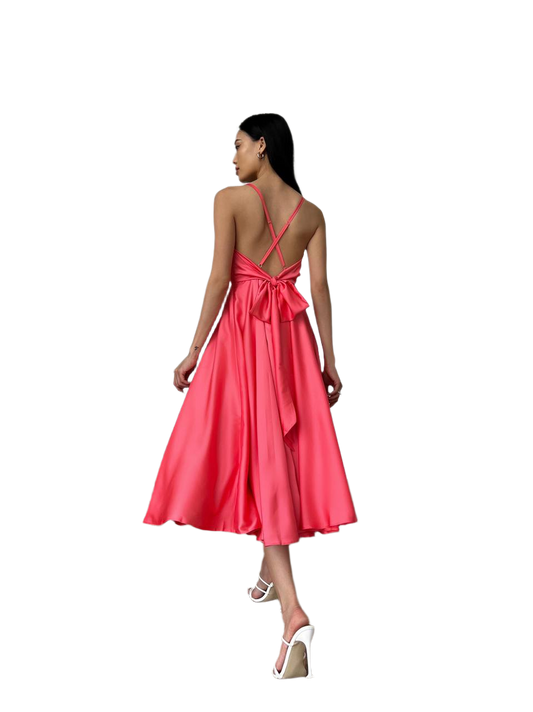 Woman wearing a pink dress with a bow detail on a white background