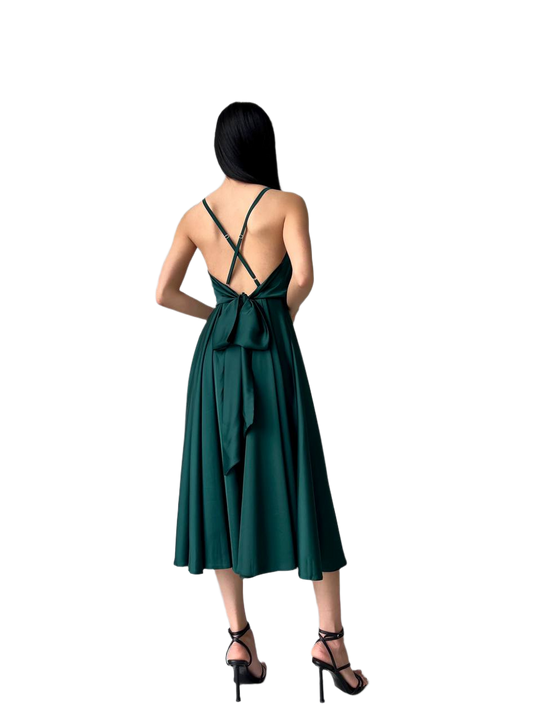 Woman wearing a green dress with a bow detail on a white background