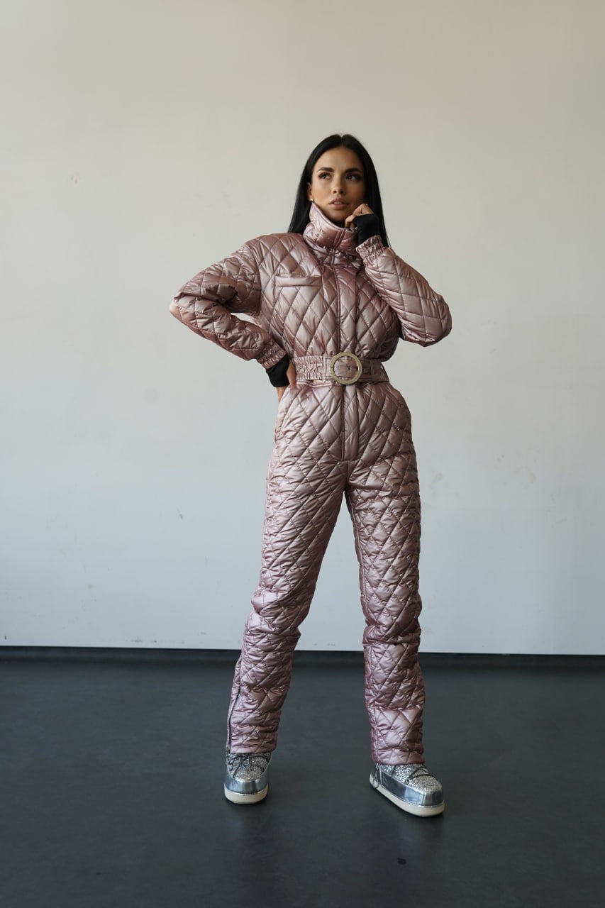 Person wearing a quilted pink snowsuit against a plain background