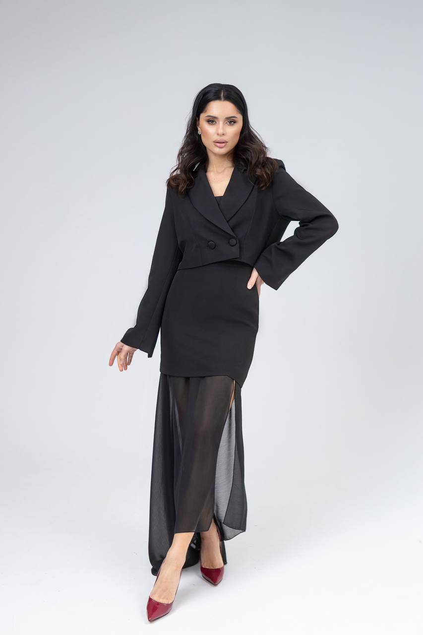 Woman wearing a black outfit with a high-low skirt on a white background