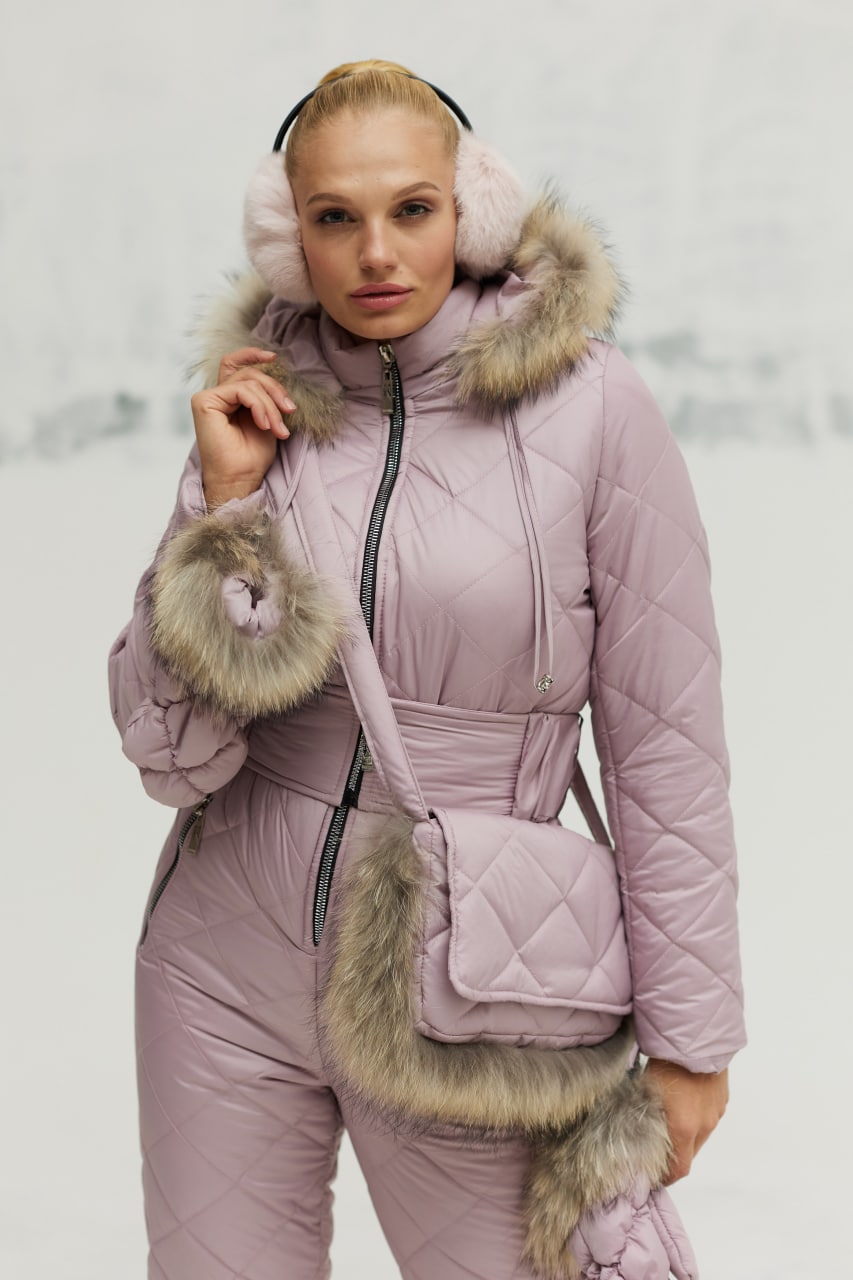 Person wearing a pink winter outfit with fur accents on a light gray background