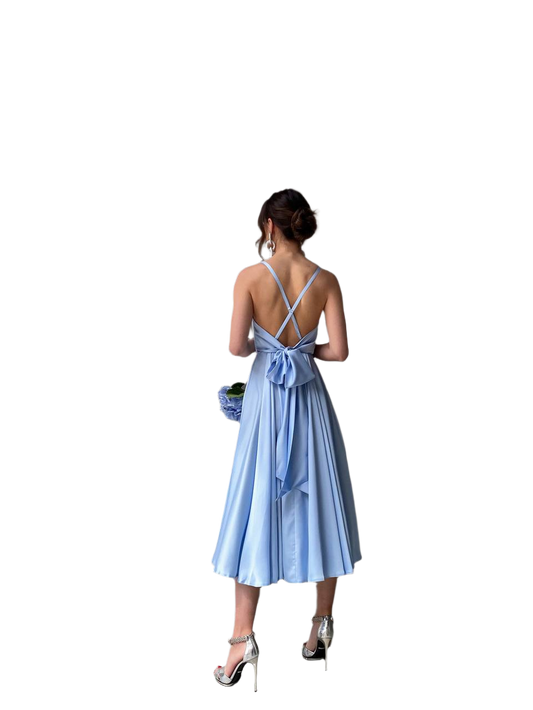 Woman wearing a light blue dress with a bow detail on a white background