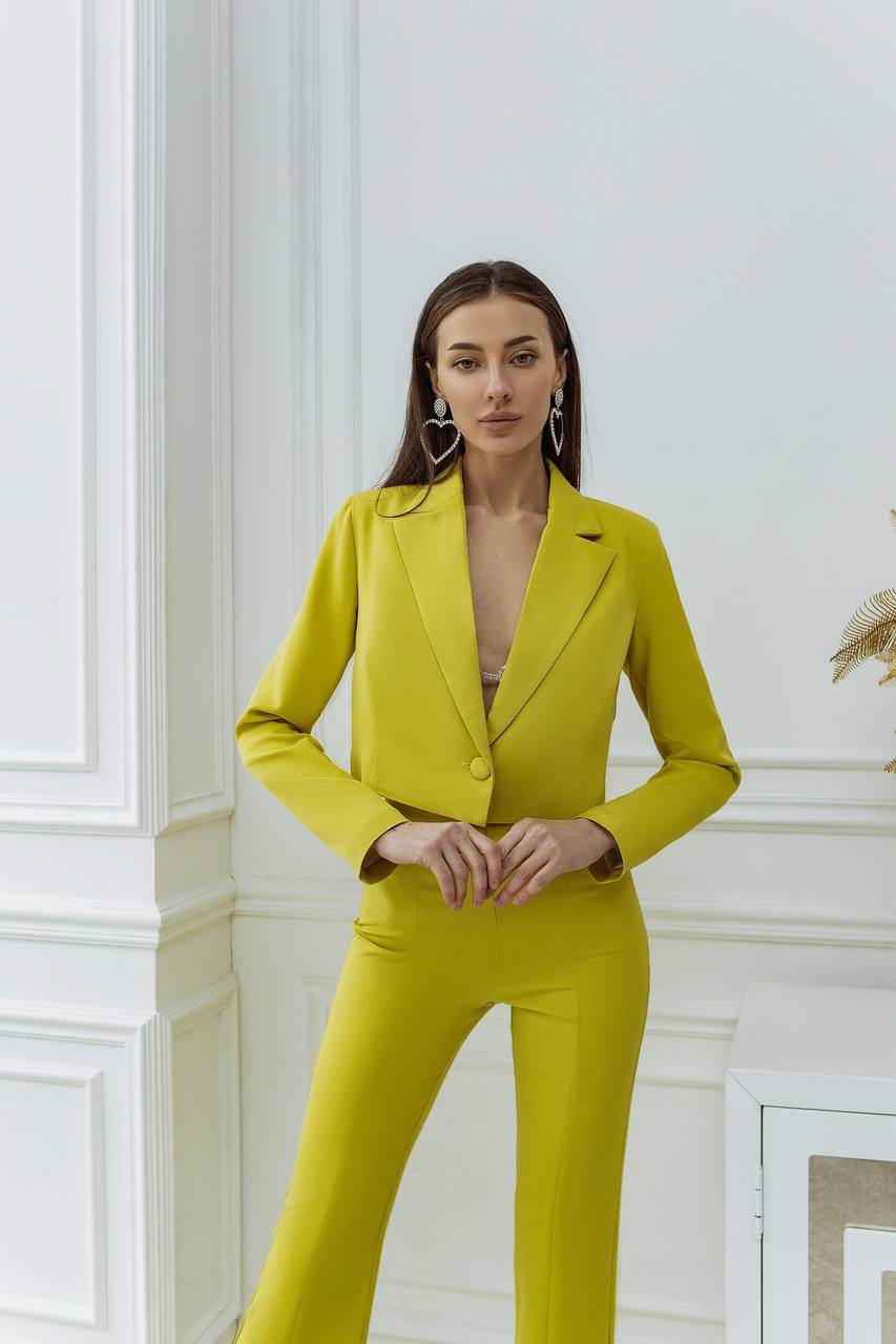 Woman wearing a bright yellow suit in an elegant interior setting
