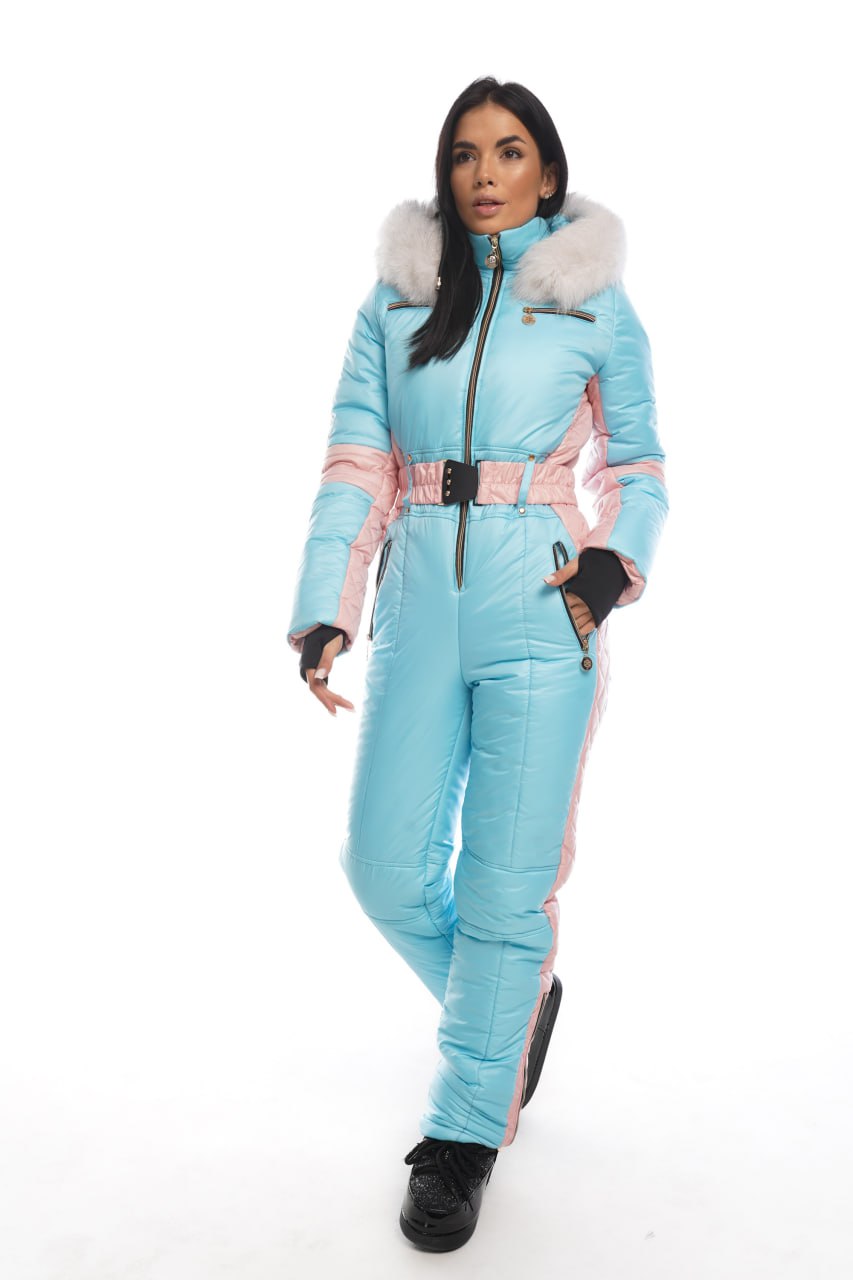 Woman wearing a light blue snowsuit with pink accents on a white background