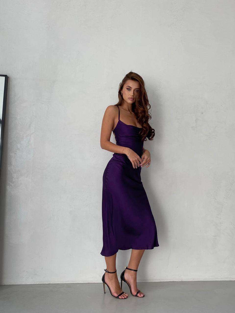 Woman wearing a purple dress against a plain background