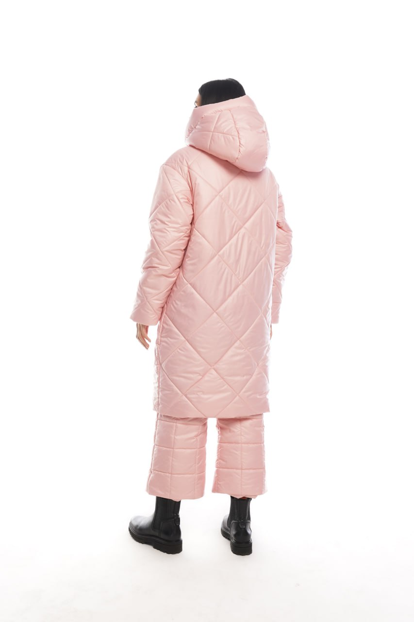 Person wearing a long pink quilted coat on a white background