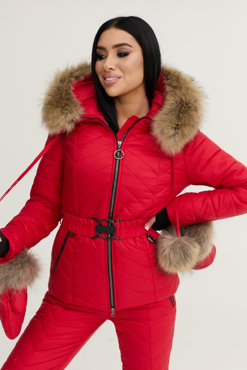 Woman wearing a red puffer suit with fur trim on a white background