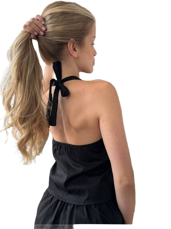 Woman with a high ponytail wearing a black halter top against a white background