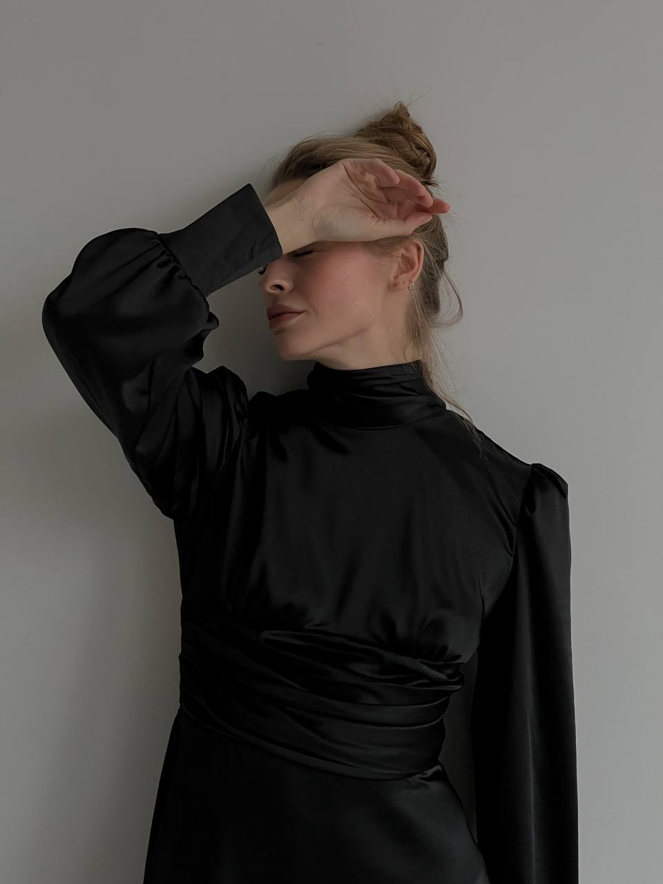 Woman wearing a black dress against a plain background