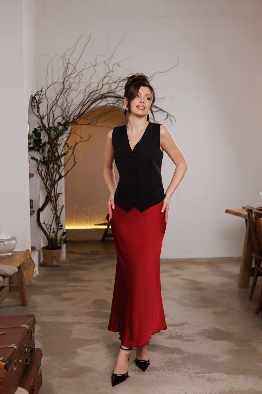 Woman wearing a black top and red skirt in an indoor setting