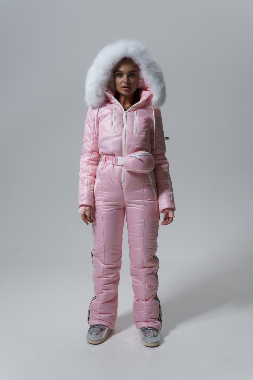 Person wearing a pink puffer suit with a fur-lined hood on a gray background