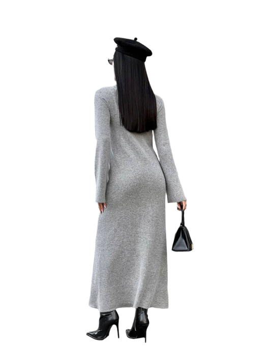 Person wearing a long gray dress with a black beret and black high-heeled shoes on a white background