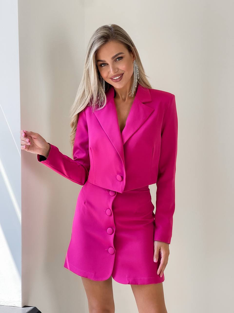 Woman wearing a bright pink suit against a neutral background