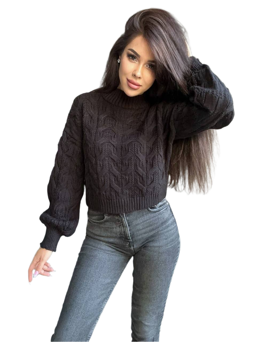 Woman wearing a dark gray cable knit sweater and light blue jeans on a white background