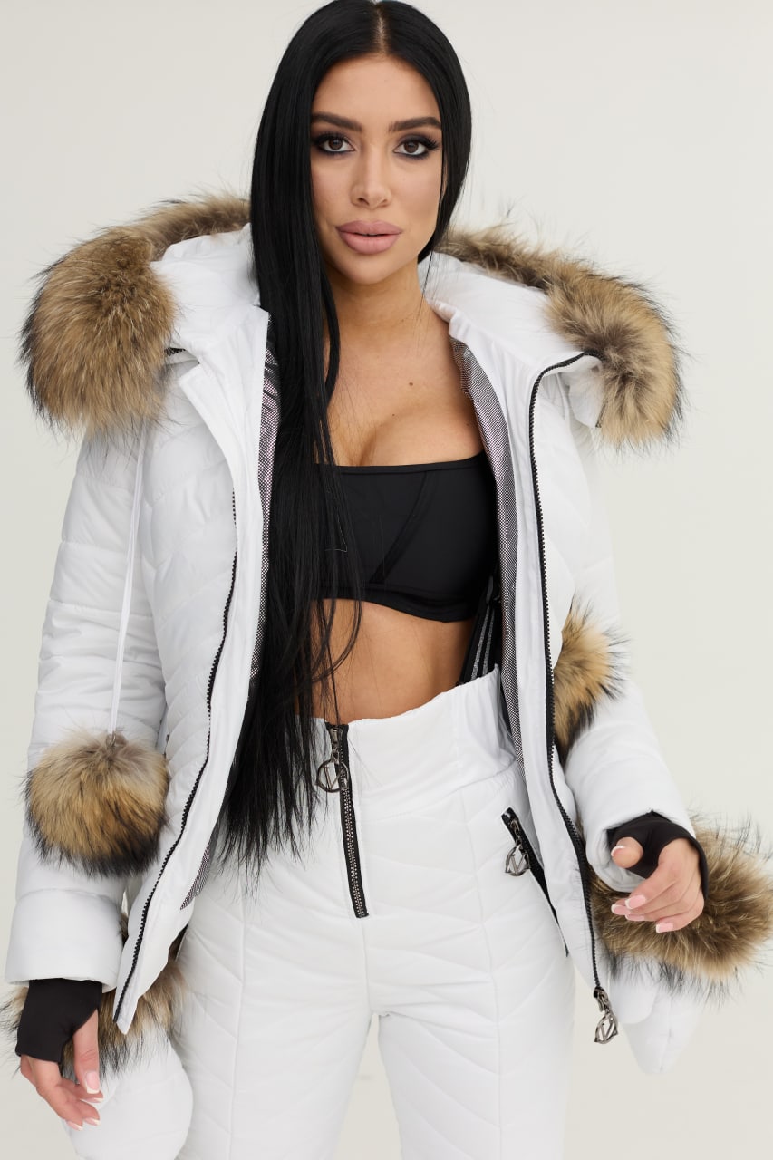 Person wearing a white winter coat with fur trim on a plain background