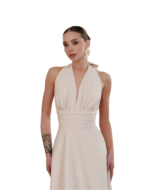 Woman wearing a beige halter neck dress on a white background