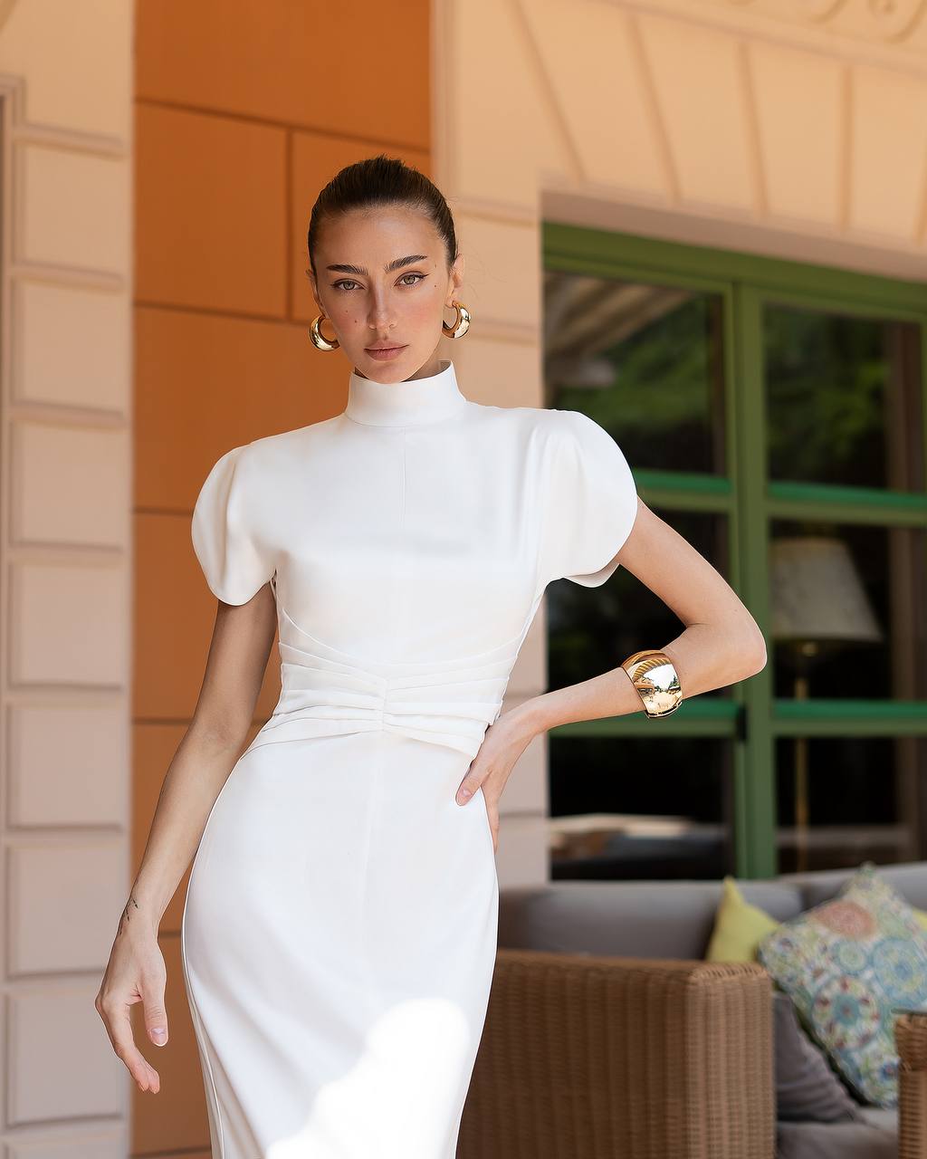 Woman in a white dress standing outdoors with a blurred background