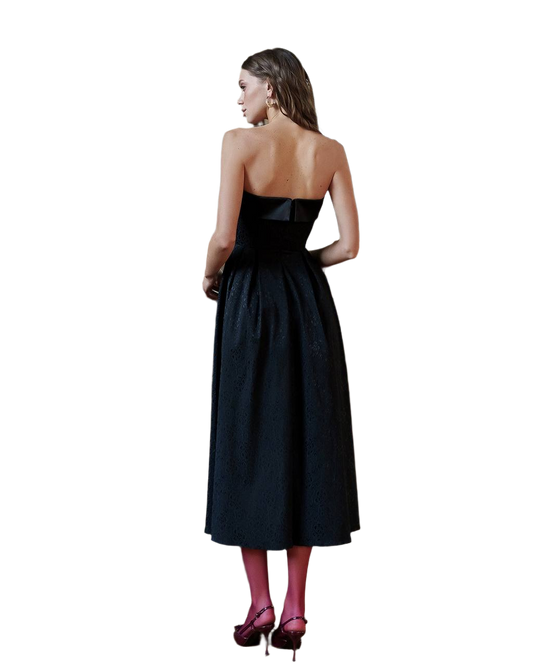 Woman wearing a black strapless dress on a white background