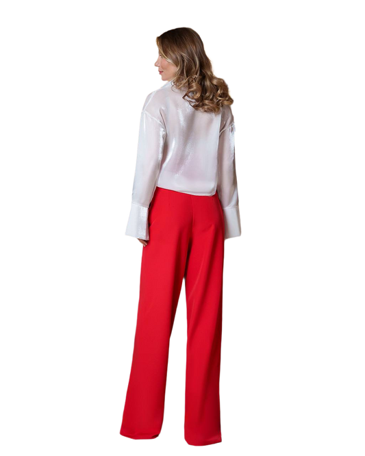 Woman wearing a white blouse and red pants on a white background