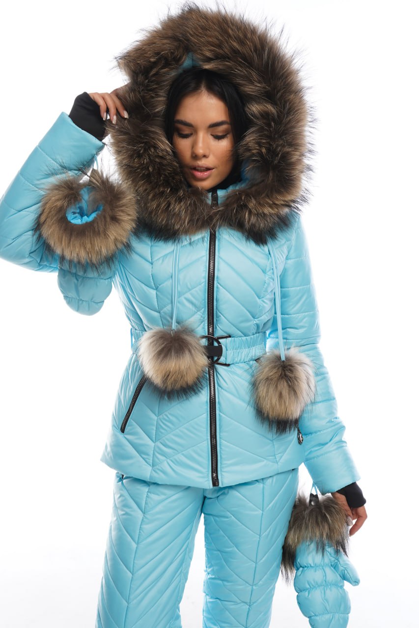 Person wearing a light blue snowsuit with fur accents on a white background