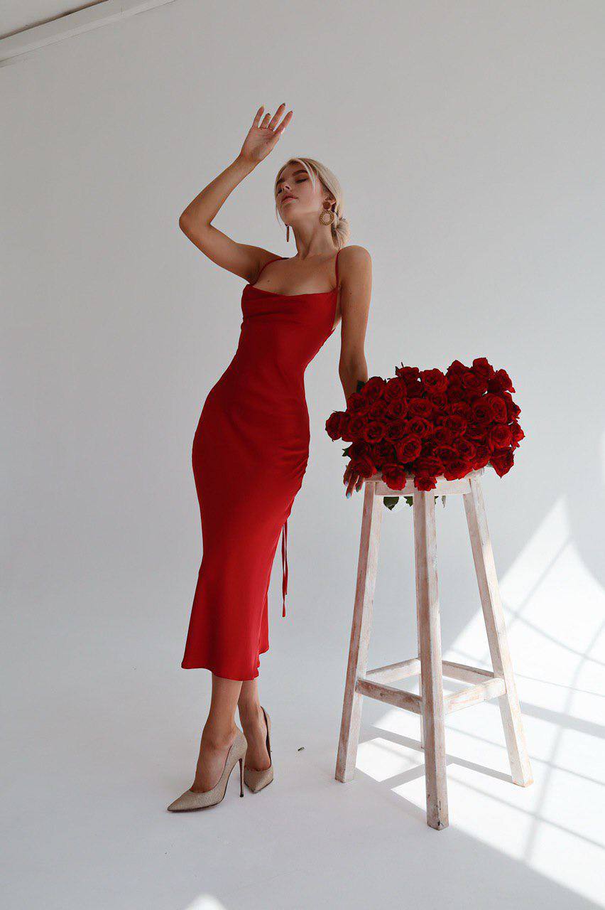 Woman in a red dress holding a bouquet of red roses on a white background