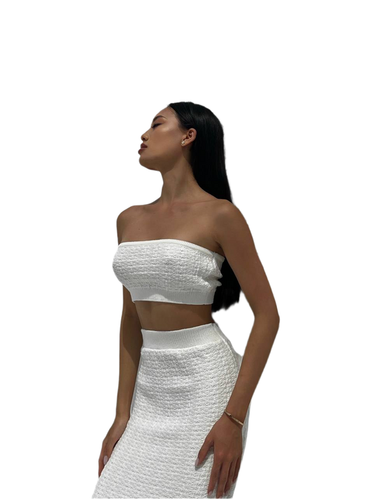 Woman wearing a white strapless top and skirt set on a white background