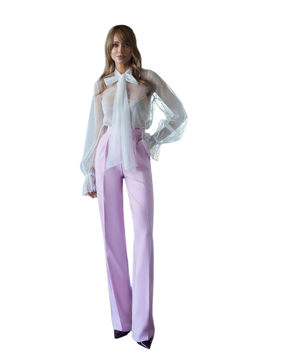 Woman wearing a white blouse with a bow and light purple pants on a white background