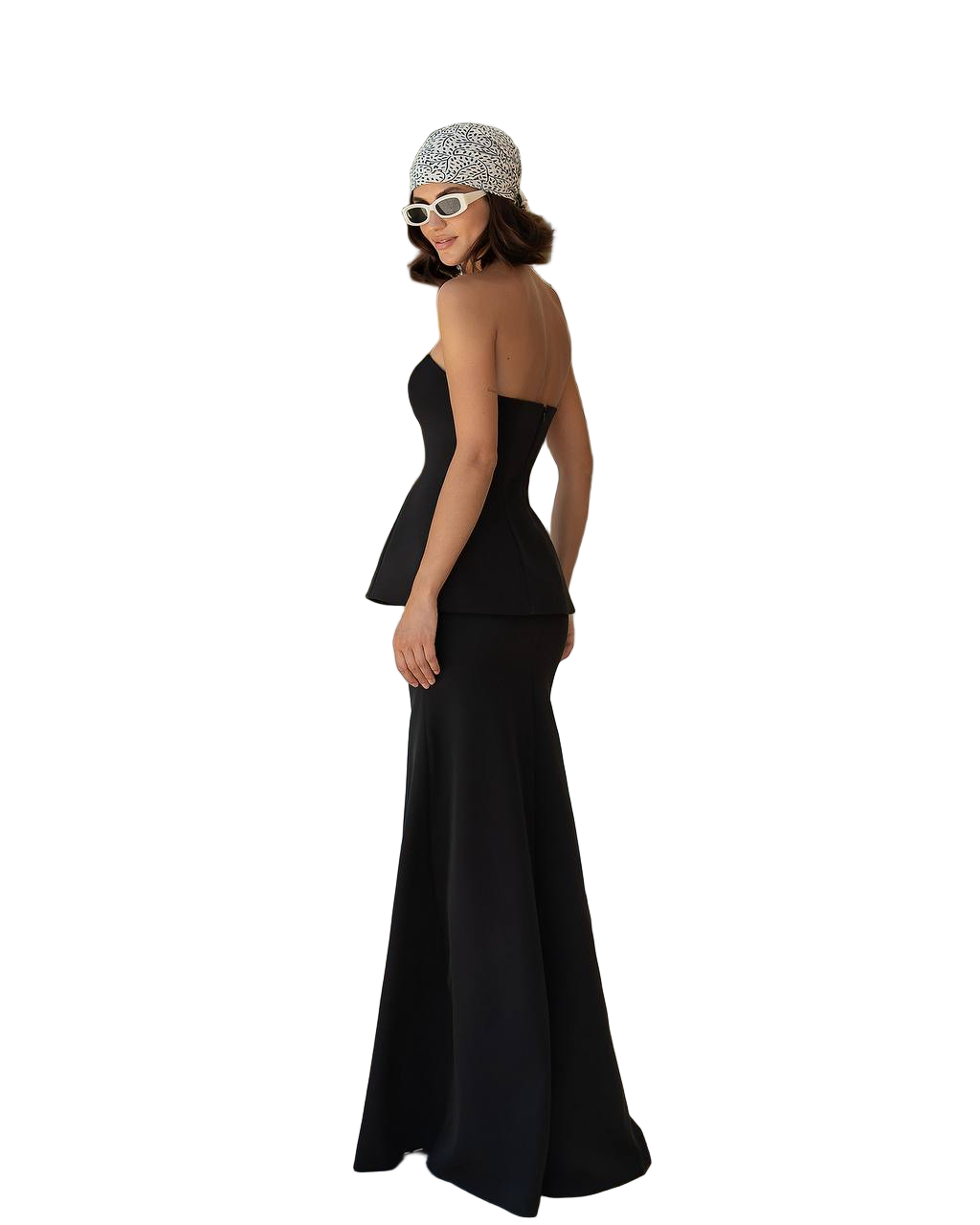 Woman wearing a black evening gown and patterned headband on a white background