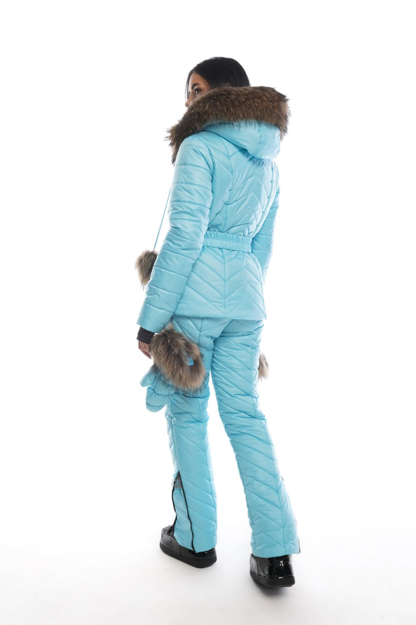 Person wearing a light blue winter suit with fur trim on a white background
