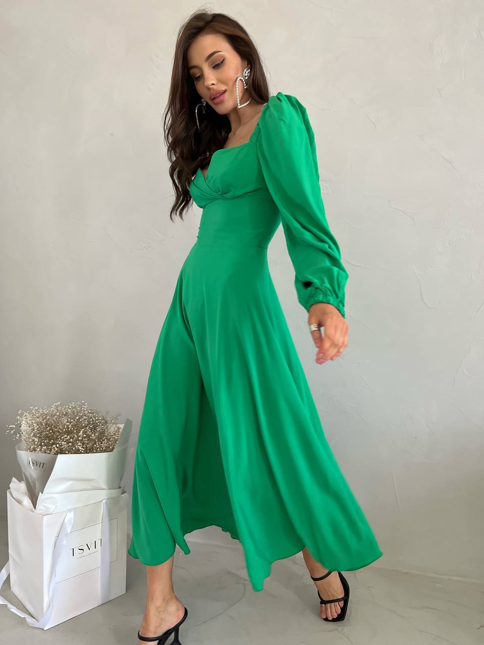 Woman wearing a green dress with a plain background