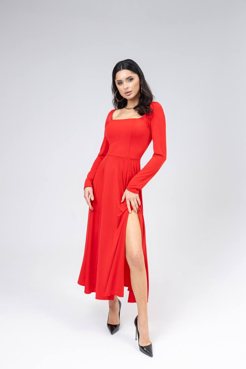 Woman wearing a red dress with a slit on a white background