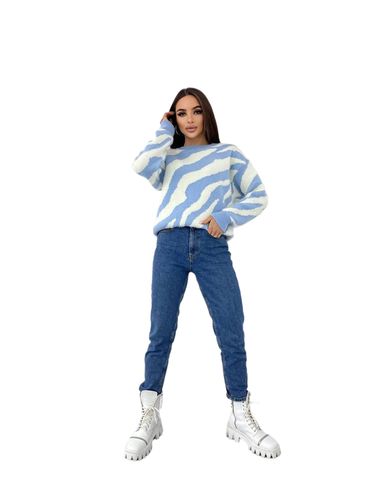 Person wearing a blue and white striped sweater with blue jeans on a white background