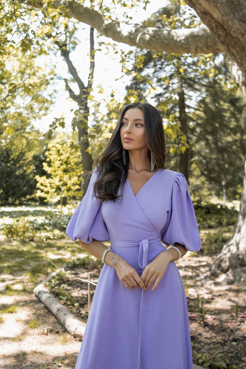 Woman in a purple dress standing in a forest