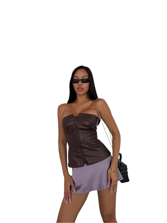 Woman wearing a brown top and purple skirt with sunglasses on a white background