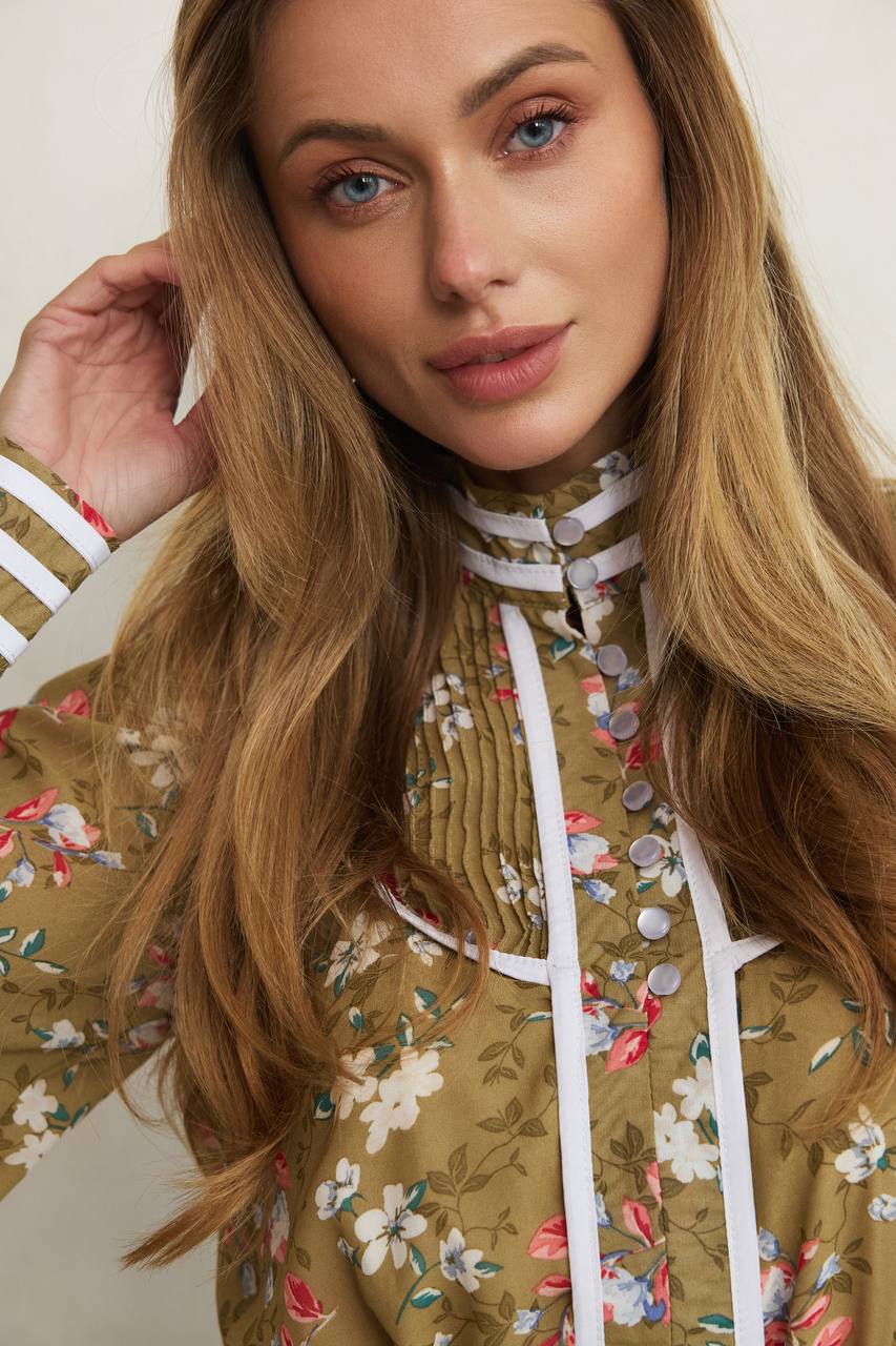 Woman wearing a floral patterned top with a white lace trim