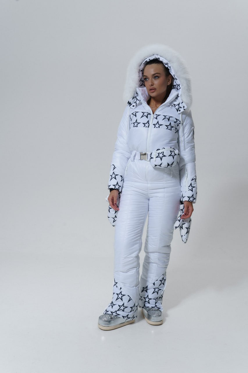 Person wearing a white and black patterned ski suit on a plain background