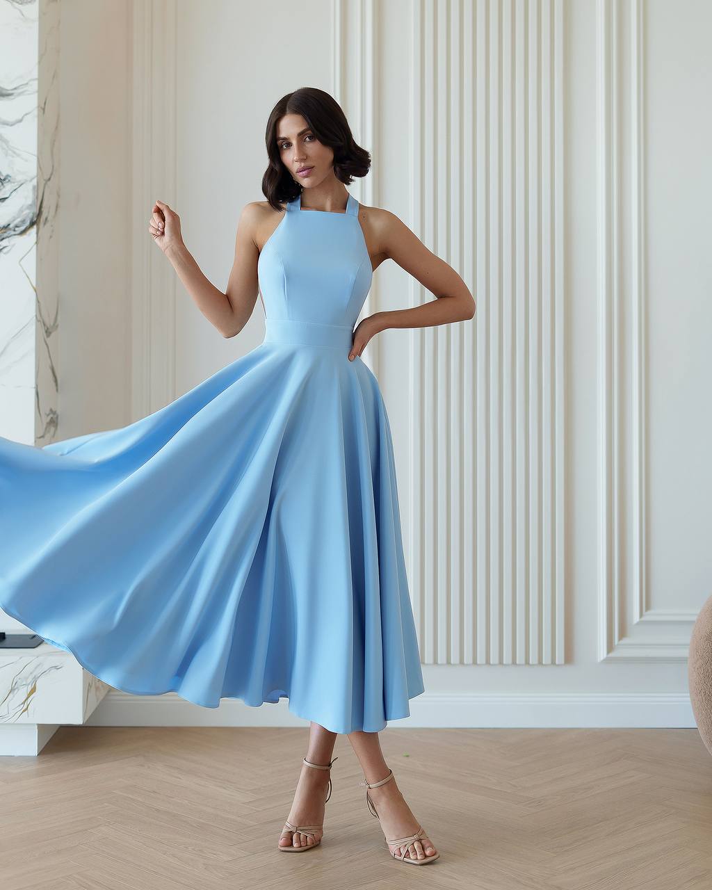 Woman wearing a light blue dress in an elegant indoor setting