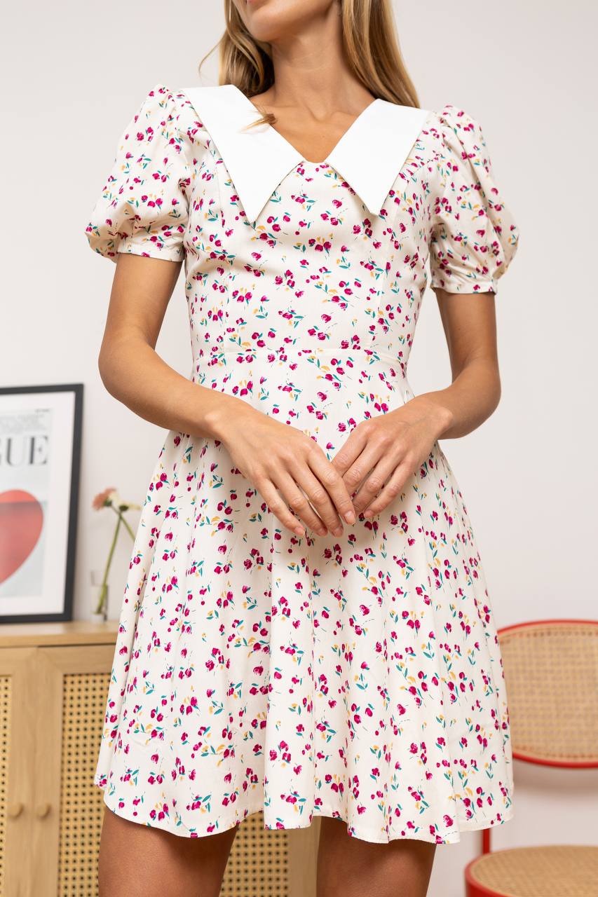 Woman wearing a floral dress in an indoor setting