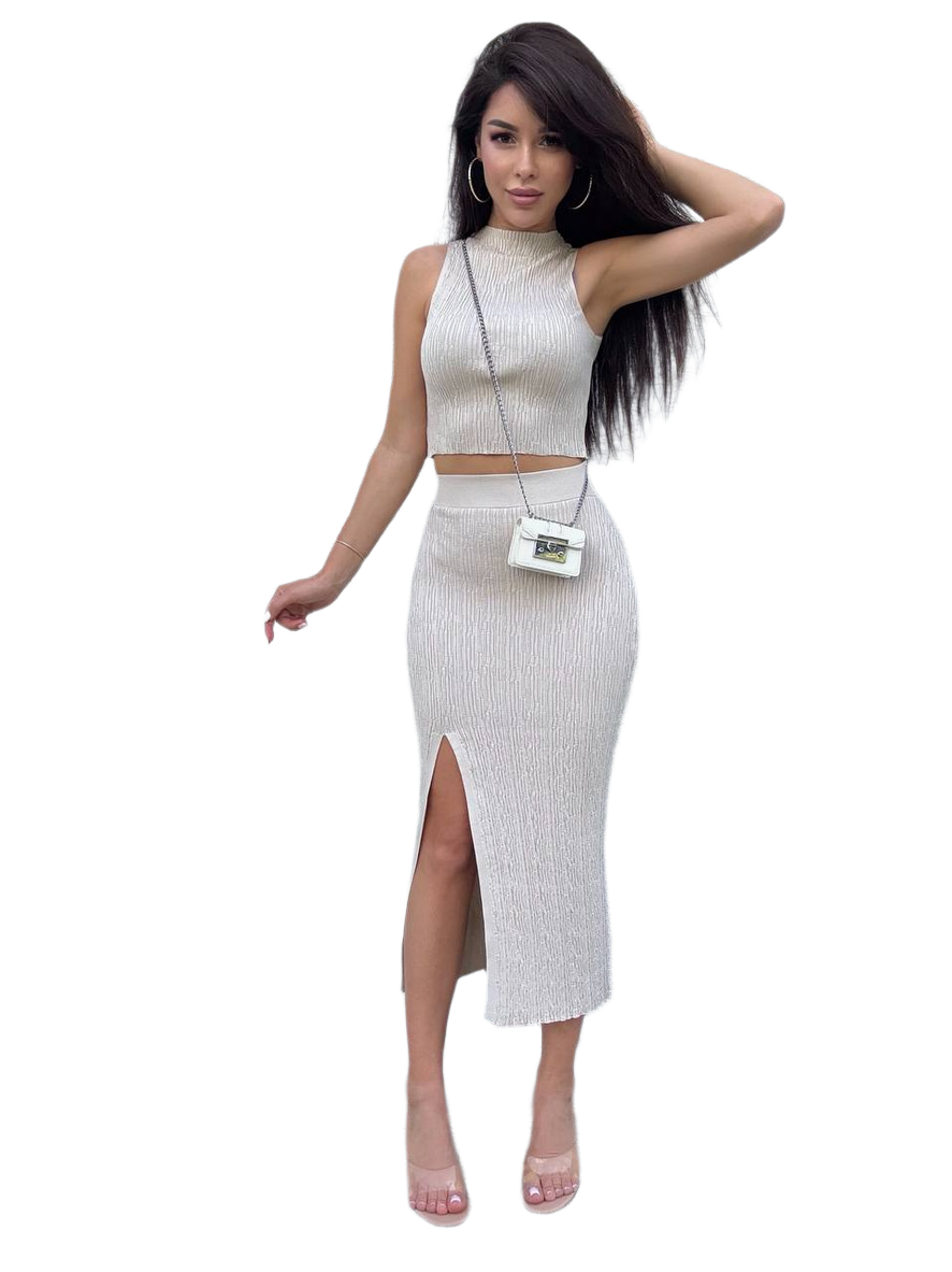 Woman wearing a white ribbed outfit with a high slit skirt on a white background