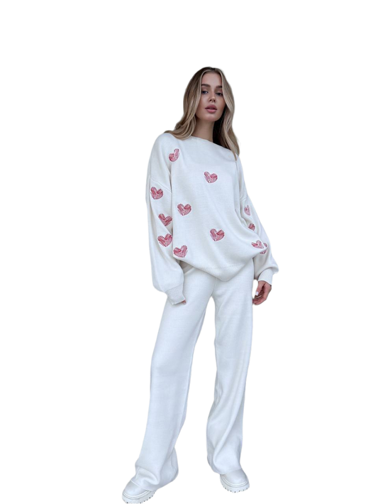 Woman wearing a white outfit with pink heart patterns on a white background