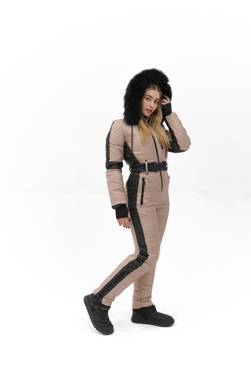 Woman wearing a beige and black snowsuit with a fur-lined hood on a white background