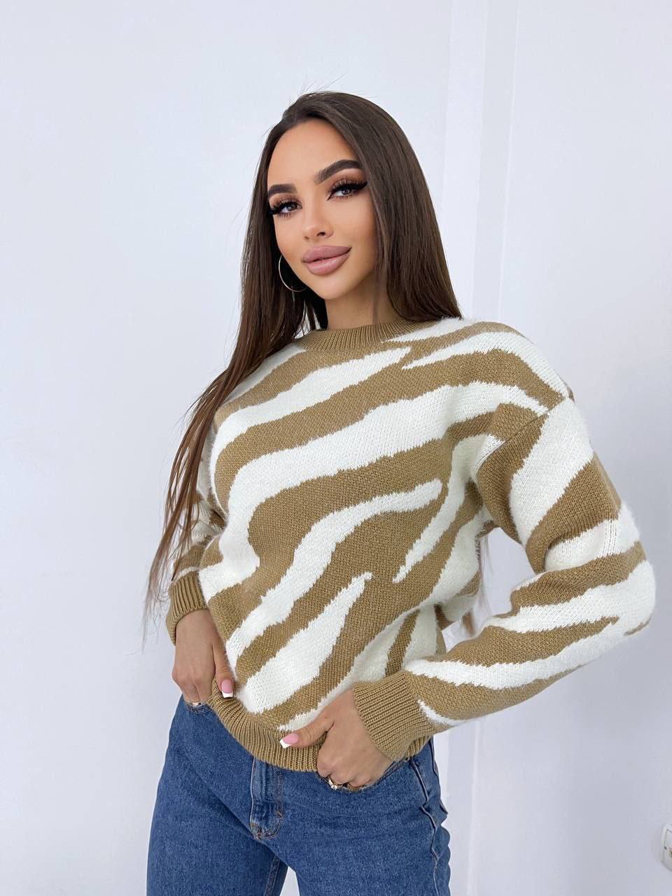 Woman wearing a brown and white striped sweater against a plain background